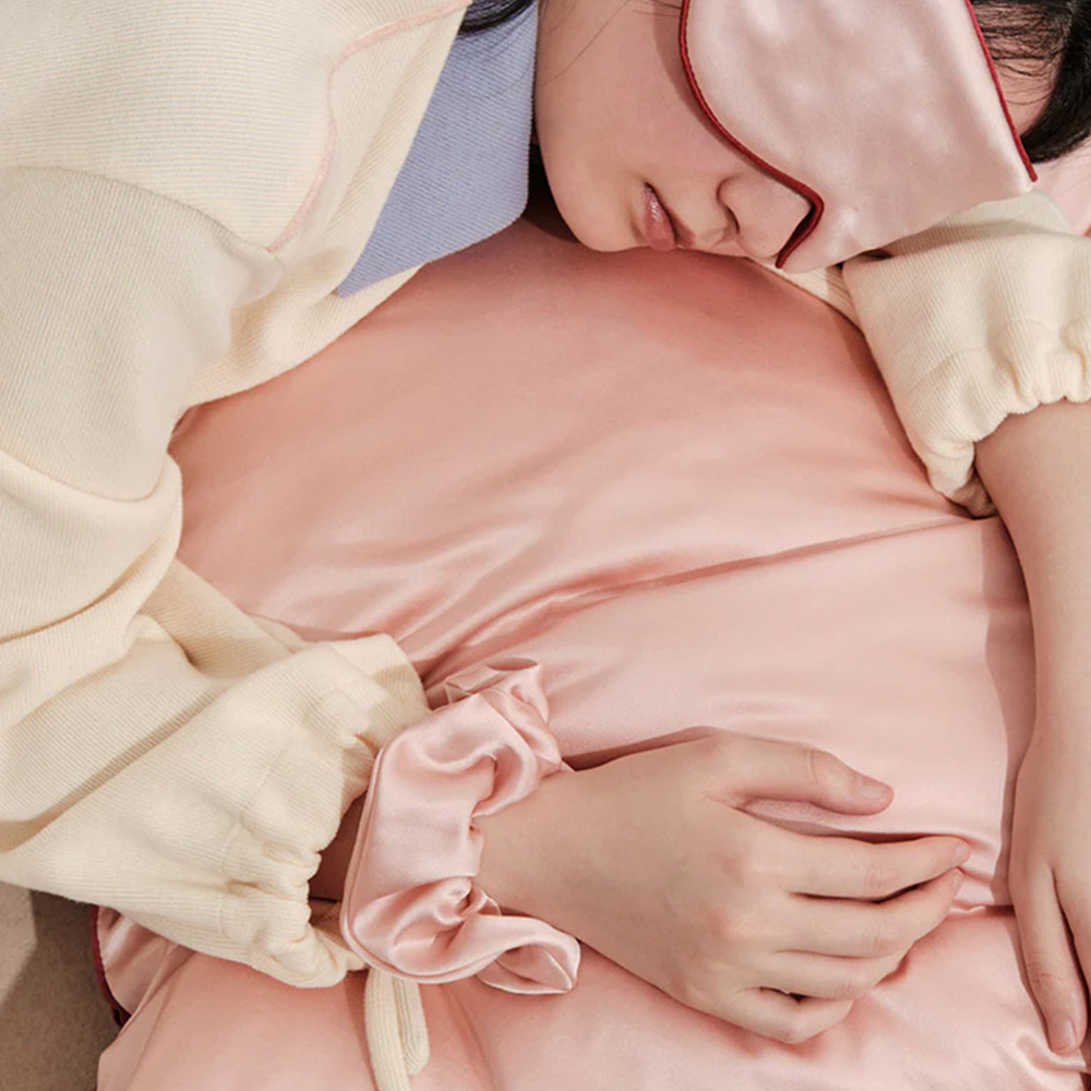 Woman sleeping with pink mulberry silk eye mask