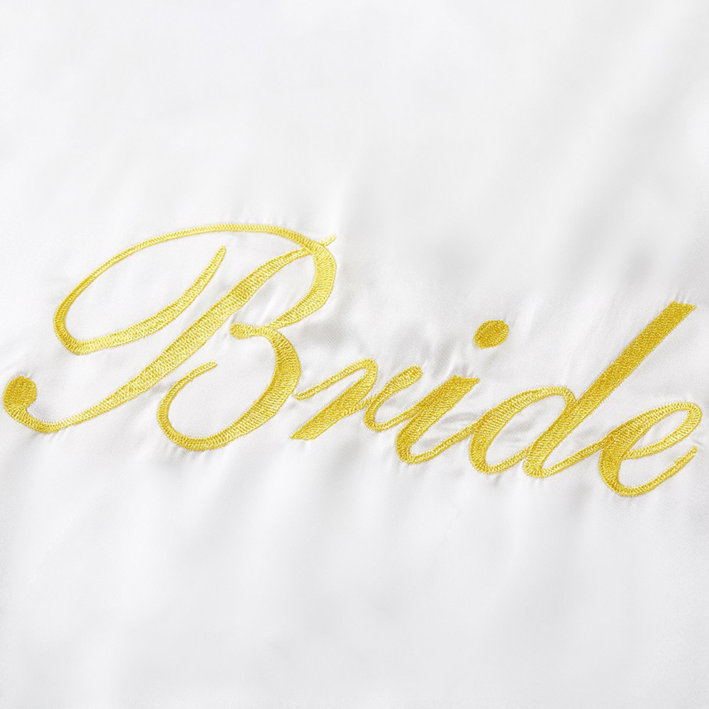 Close up of gold Bride embroidery on white silk robe