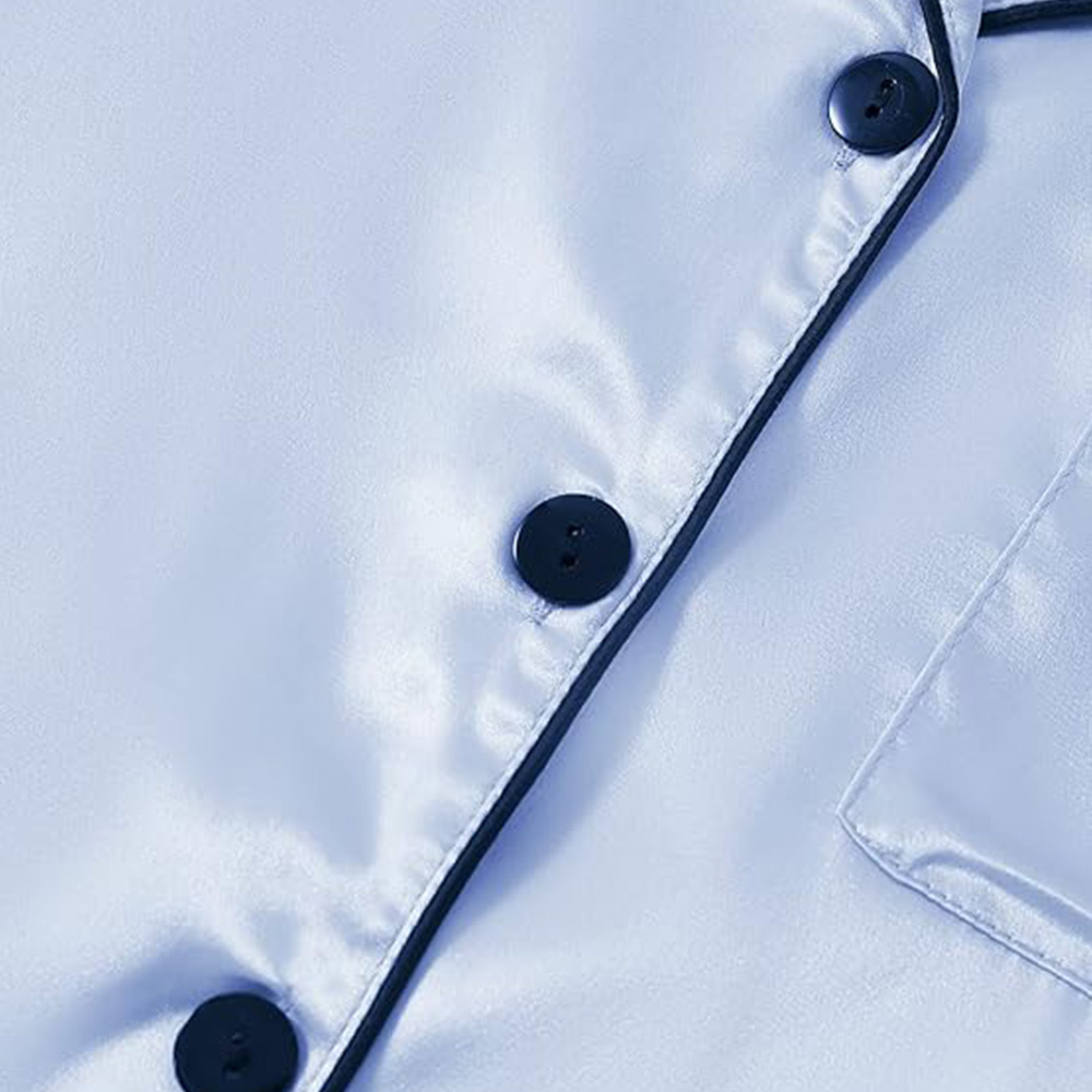 Close up of buttons and piping on light blue silk pajama